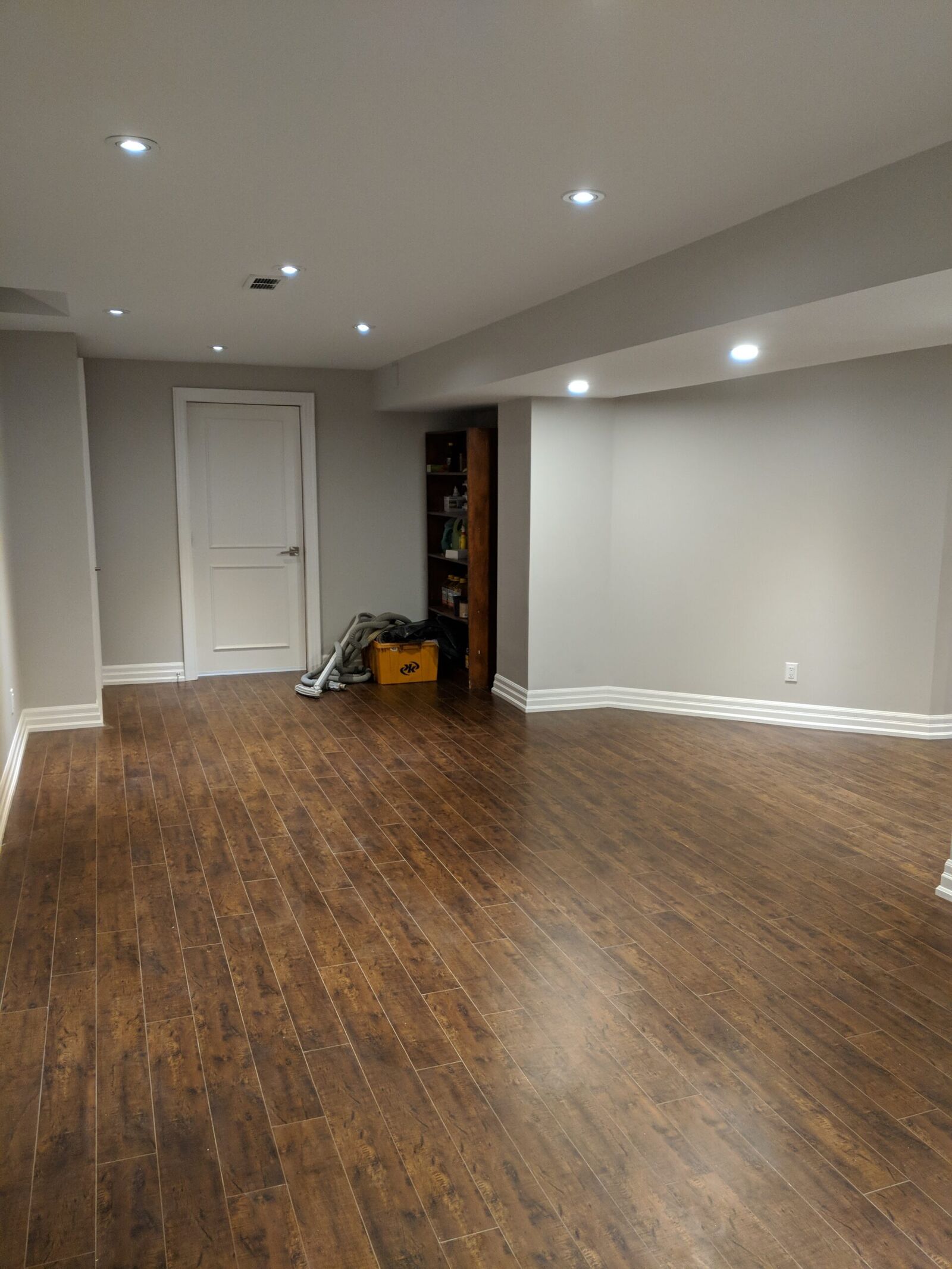 Vaughan finished basement: open living area with wood-look flooring and pot lights