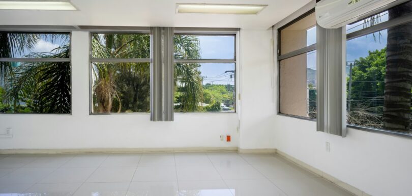 Empty white commercial room with tiled floor and windows