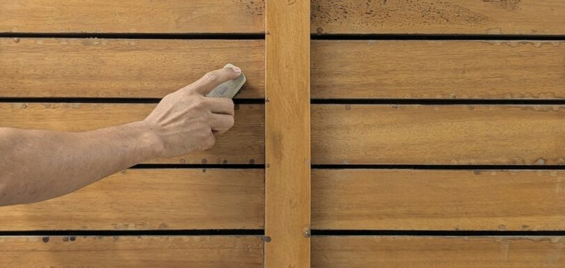 Hand sanding a wooden plank before finishing